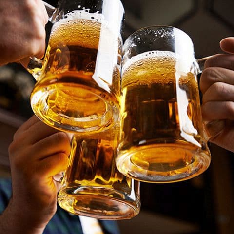 Three glasses of draft beer raised in a toast at Sakura Asian Dining & Bar