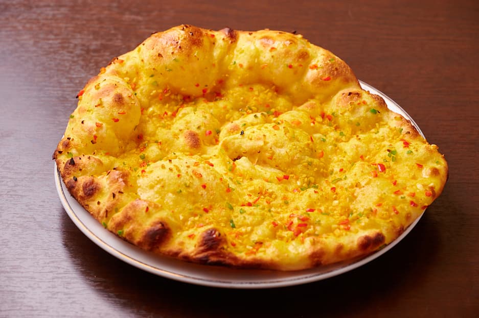 Round naan topped with golden melted cheese at Sakura Asian Dining & Bar