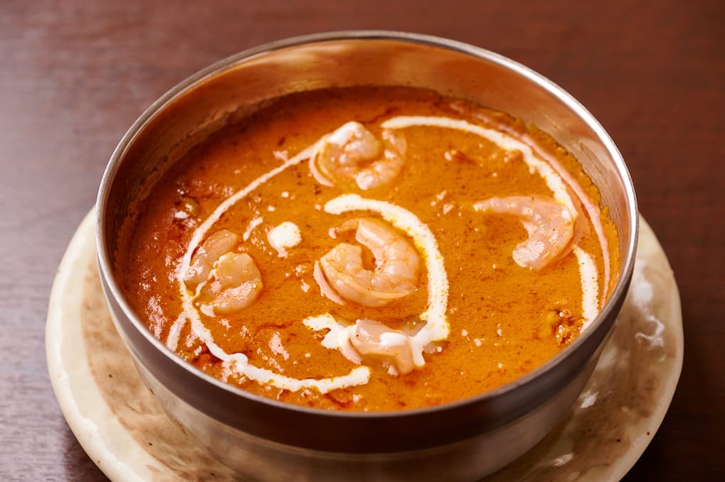 Orange curry garnished with cream and cashews at Sakura Asian Dining & Bar