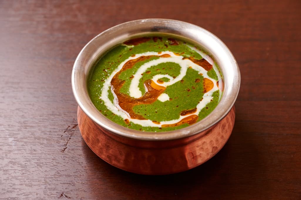 Spinach curry served in a copper bowl at Sakura Asian Dining & Bar