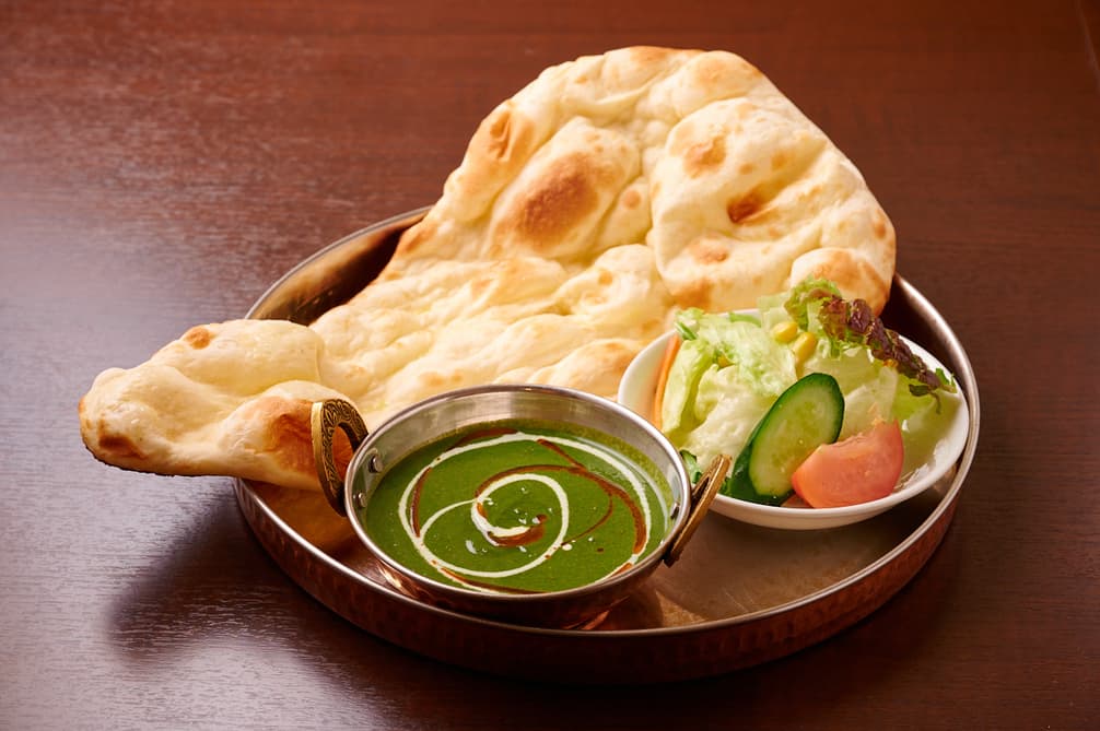Naan served with spinach curry and salad at Sakura Asian Dining & Bar