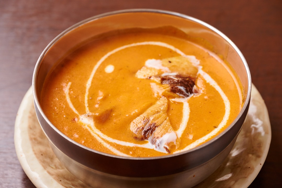 クリームを添えたオレンジ色のカレー